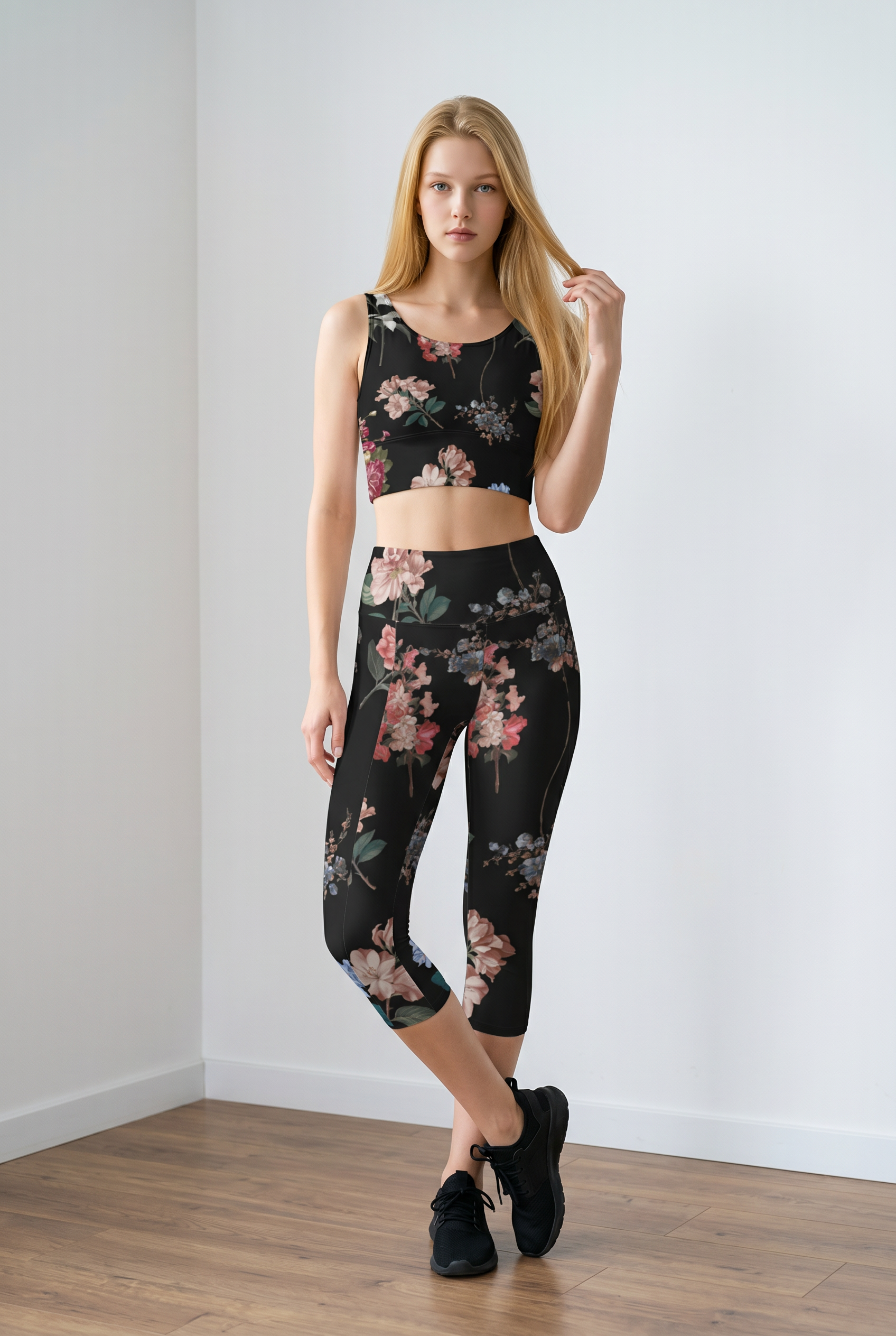 Cropped black crop top with colorful floral print, worn with matching leggings and black sneakers; model poses confidently.