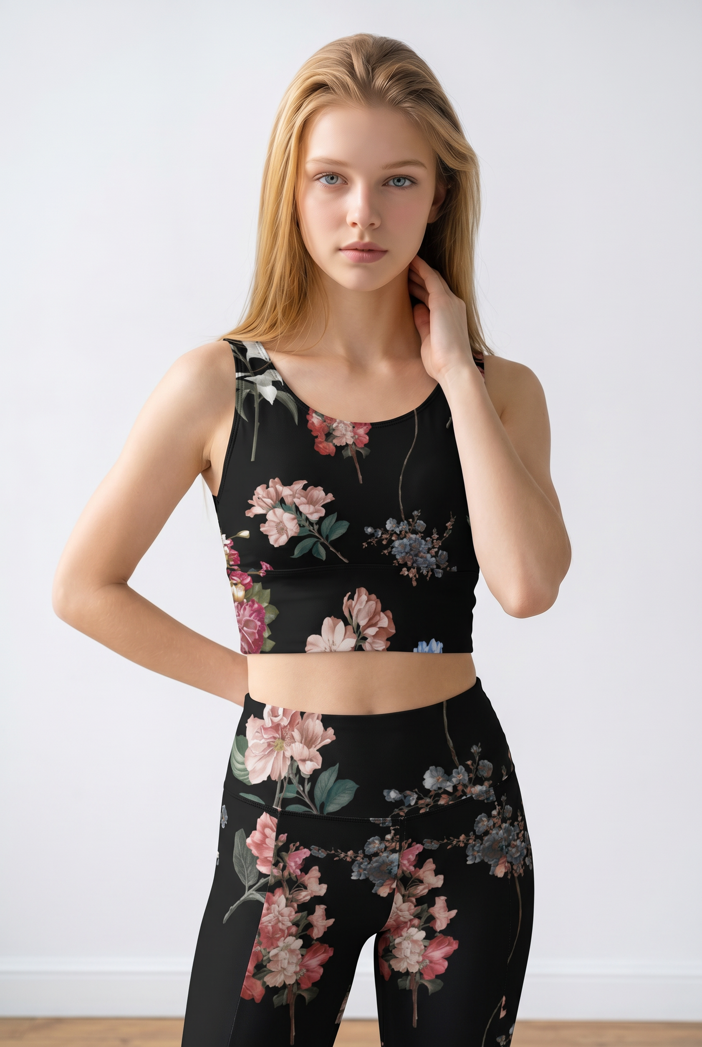 Black cropped top featuring a vibrant floral pattern, paired with matching leggings, showcasing a stylish and sporty look.