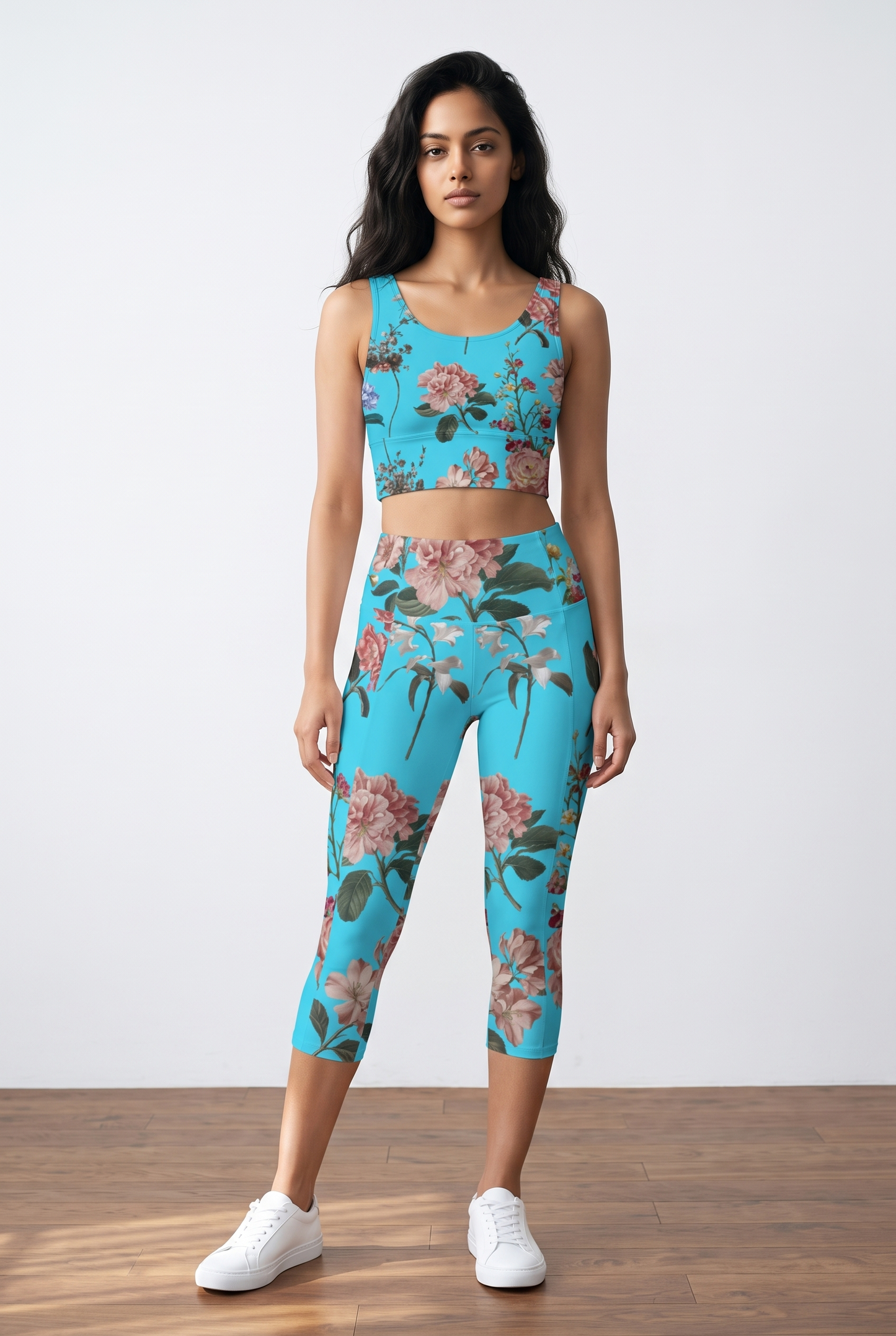 Cropped turquoise crop top with floral print, paired with matching leggings, worn by a model in white sneakers.